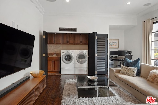 laundry area with washer and dryer, sink, cabinets, ornamental molding, and dark wood-type flooring