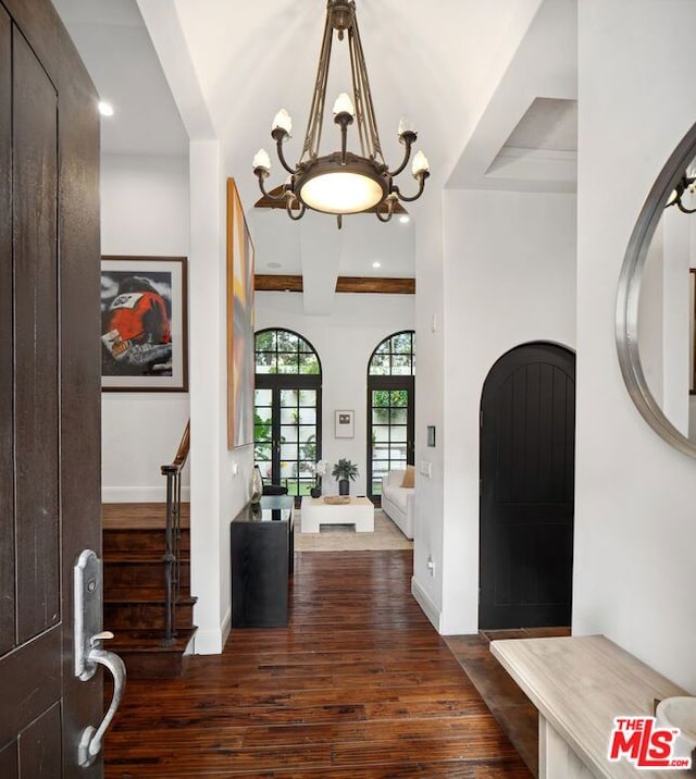 entrance foyer featuring beam ceiling, a chandelier, and dark hardwood / wood-style flooring