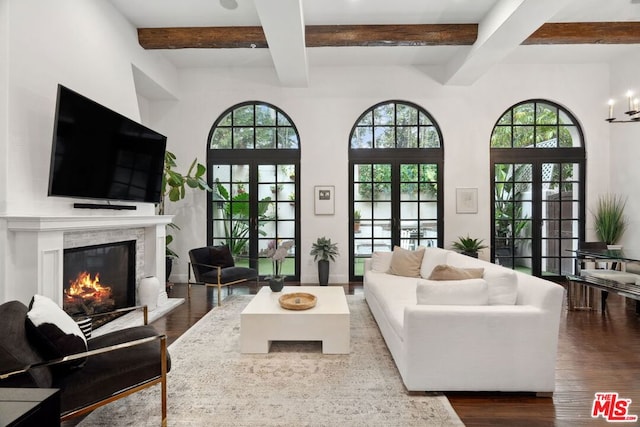 living room with french doors, dark hardwood / wood-style flooring, an inviting chandelier, and beamed ceiling