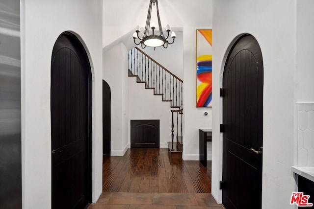 foyer with dark hardwood / wood-style floors and a notable chandelier