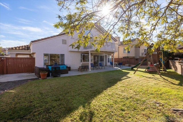 back of property featuring a yard, a patio, and a playground