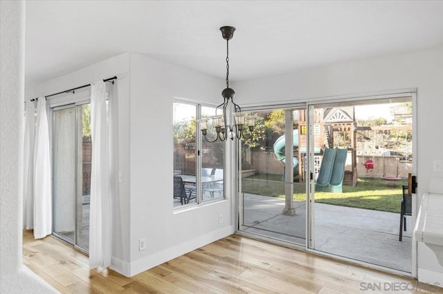 doorway to outside featuring an inviting chandelier and hardwood / wood-style floors