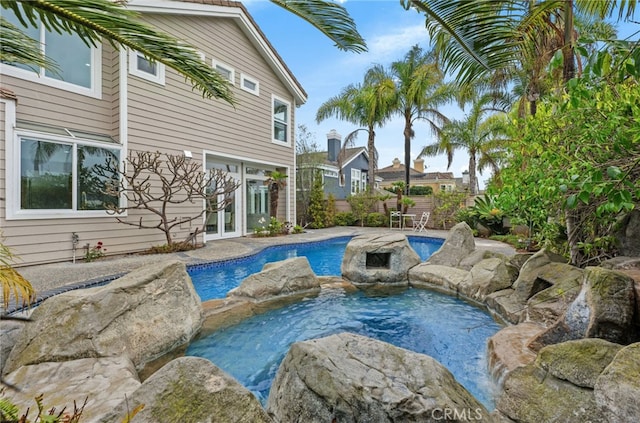 view of swimming pool with an in ground hot tub, fence, a fenced in pool, and french doors