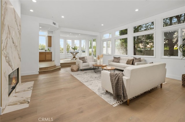 sunroom / solarium with heating unit, a premium fireplace, and visible vents