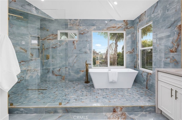 full bath with a marble finish shower, a freestanding bath, and vanity