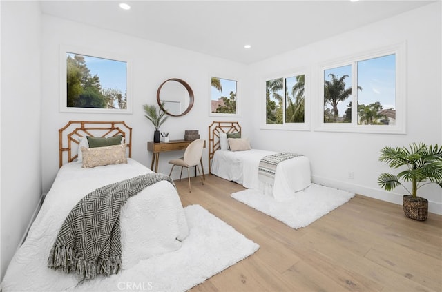 bedroom with baseboards, wood finished floors, and recessed lighting