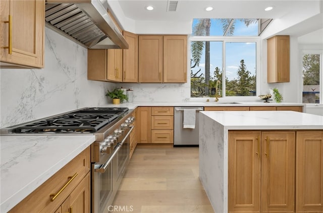 kitchen featuring visible vents, wall chimney exhaust hood, light stone countertops, stainless steel appliances, and backsplash