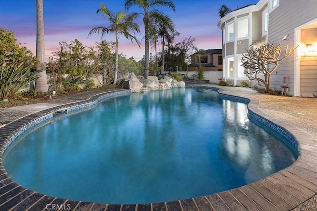 pool at dusk featuring an outdoor pool