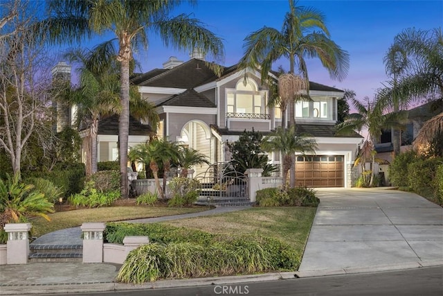 view of front of home with a garage, fence, and concrete driveway