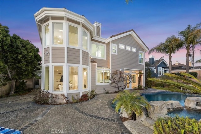 rear view of house with an outdoor pool