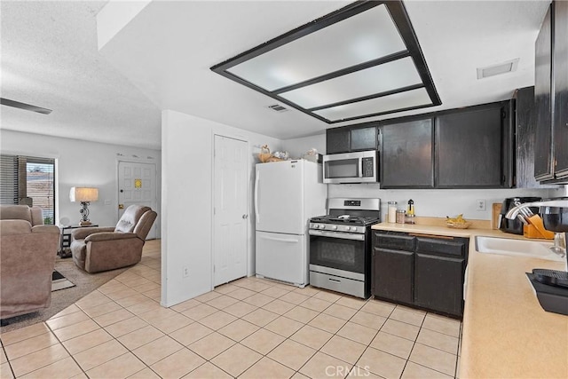 kitchen featuring appliances with stainless steel finishes, sink, and light tile patterned floors