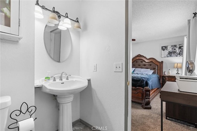 bathroom featuring sink, toilet, and a textured ceiling