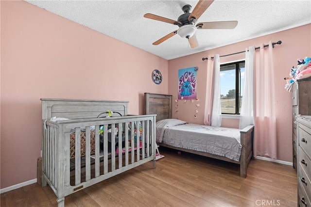 bedroom featuring ceiling fan, a textured ceiling, and light hardwood / wood-style flooring