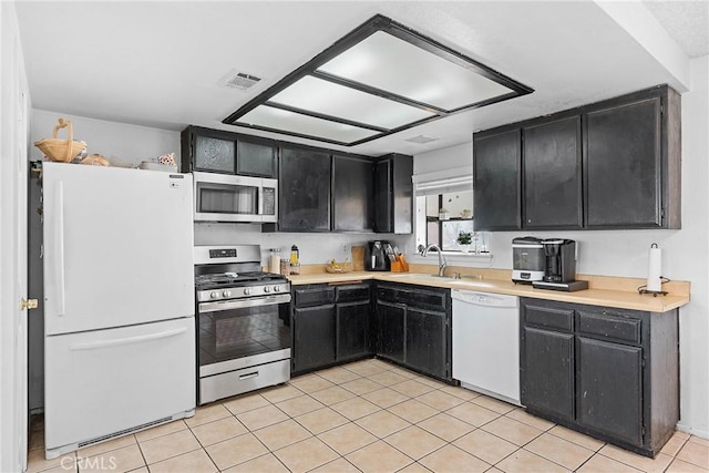 kitchen featuring light tile patterned flooring, stainless steel appliances, and sink