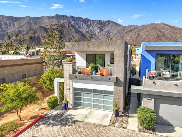 contemporary home with a mountain view, a garage, and a balcony