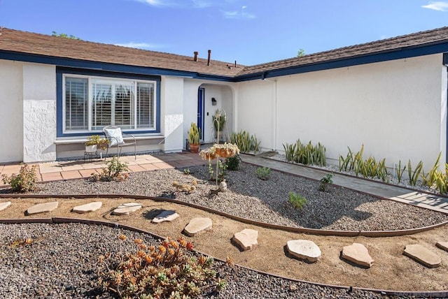 view of exterior entry with a patio