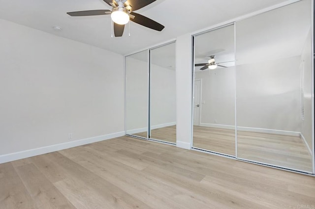 unfurnished bedroom featuring two closets, ceiling fan, and light hardwood / wood-style flooring