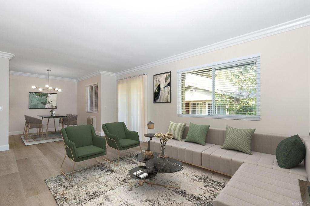 living room featuring an inviting chandelier, ornamental molding, and light wood-type flooring