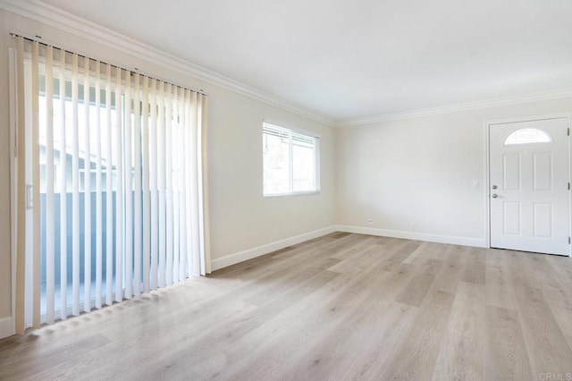 empty room with crown molding and light wood-type flooring