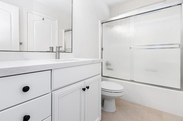 full bathroom featuring tile patterned flooring, vanity, enclosed tub / shower combo, and toilet