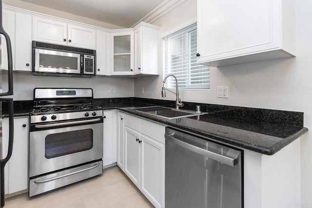 kitchen with dark stone countertops, sink, stainless steel appliances, and white cabinets