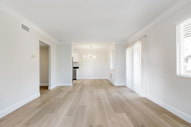 unfurnished living room with crown molding, light hardwood / wood-style floors, and a notable chandelier