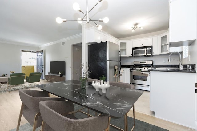 kitchen featuring stainless steel appliances, white cabinetry, sink, and light hardwood / wood-style flooring