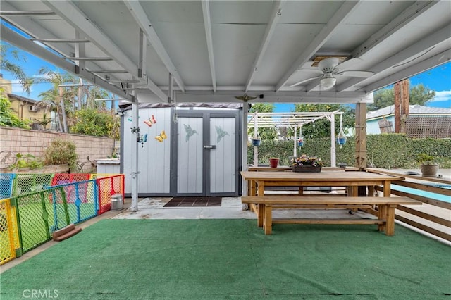 exterior space with ceiling fan and a storage unit