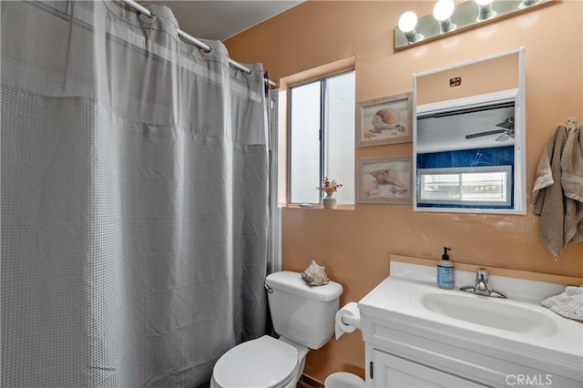 bathroom featuring vanity, toilet, and curtained shower