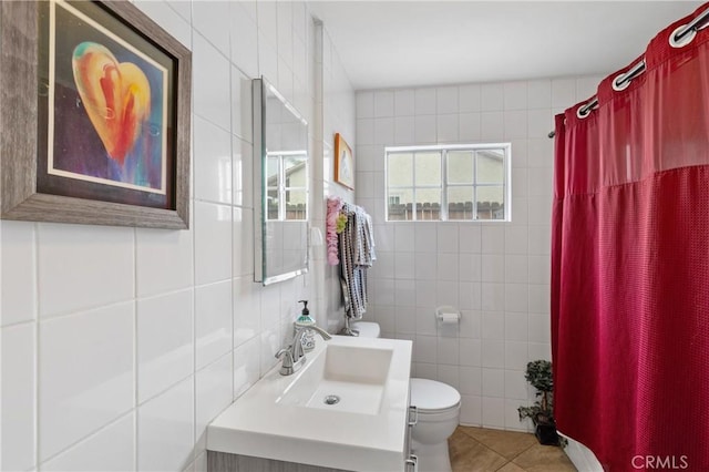 bathroom featuring vanity, toilet, tile patterned flooring, and tile walls