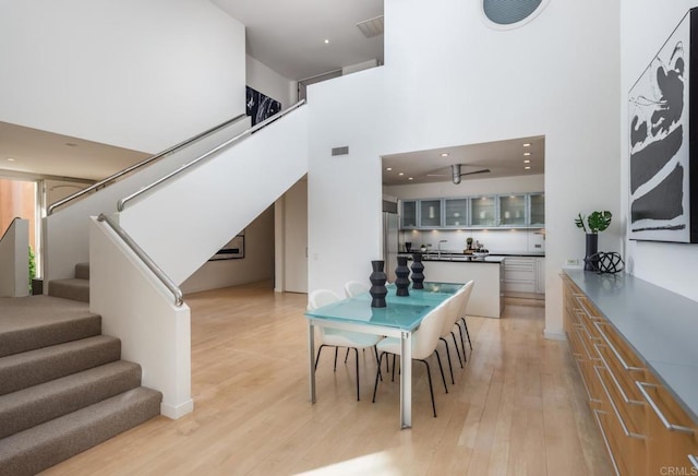 dining space with a high ceiling and light hardwood / wood-style floors