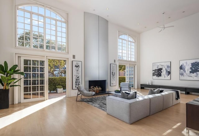 living room with a towering ceiling and light wood-type flooring