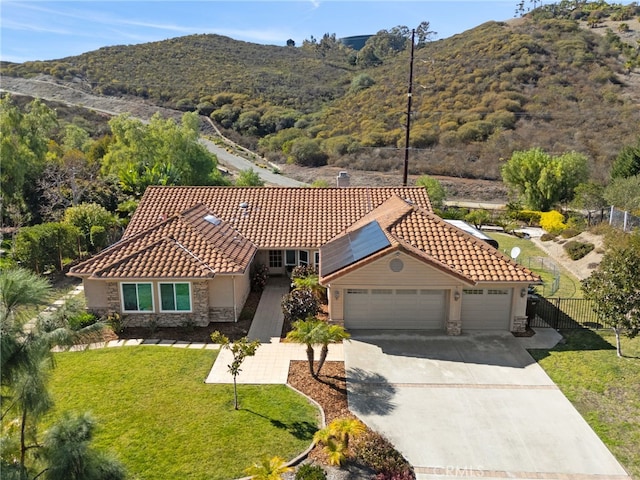 view of front of property featuring a garage, a mountain view, and a front lawn