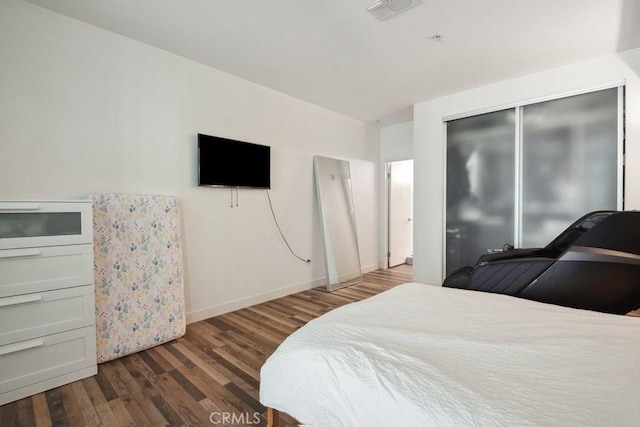 bedroom featuring dark wood-type flooring and a closet