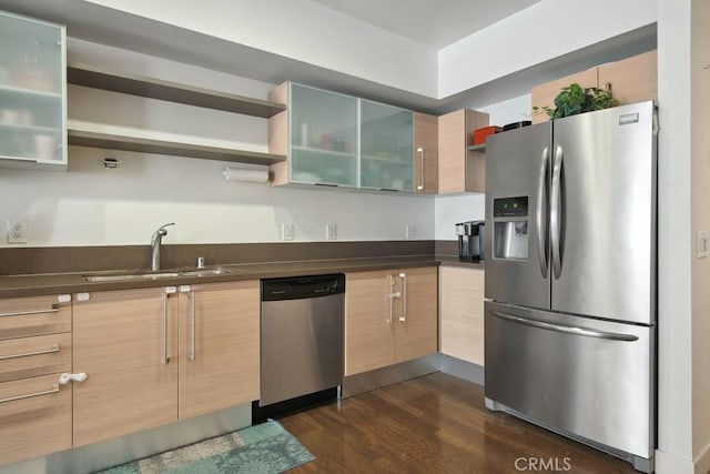 kitchen featuring stainless steel appliances, sink, light brown cabinetry, and dark hardwood / wood-style floors