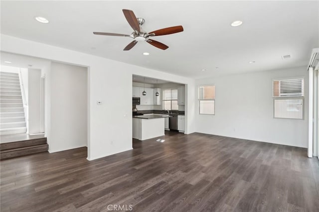 unfurnished living room with ceiling fan and dark hardwood / wood-style flooring