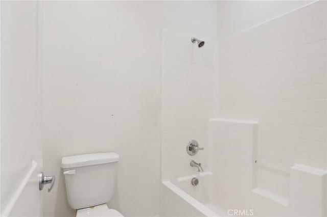 bathroom featuring bathtub / shower combination and toilet