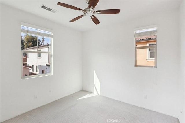 carpeted spare room with ceiling fan