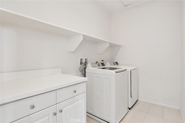 laundry room featuring cabinets, light tile patterned flooring, and washer and dryer