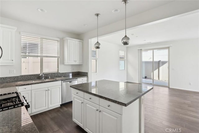 kitchen featuring sink, white cabinetry, decorative light fixtures, dark stone countertops, and stainless steel dishwasher