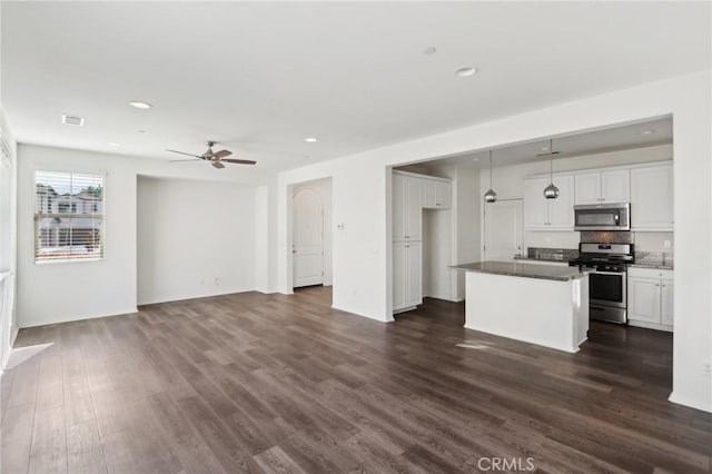 unfurnished living room featuring dark wood-type flooring and ceiling fan