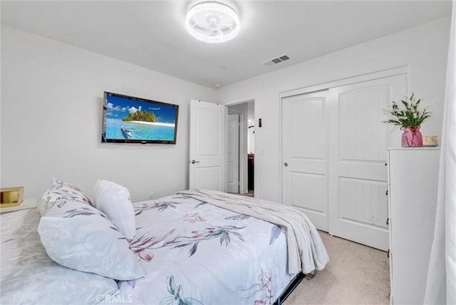 bedroom with light carpet, visible vents, and a closet