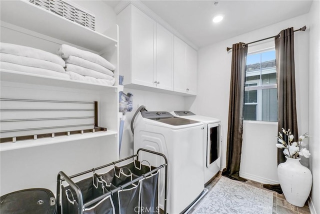 clothes washing area with washing machine and clothes dryer, cabinet space, and recessed lighting