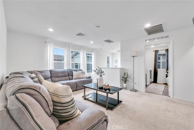 living room featuring light colored carpet, baseboards, and visible vents