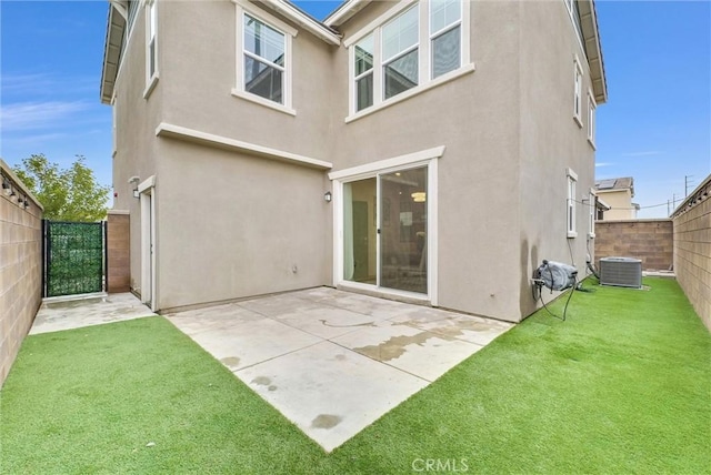 back of house featuring a fenced backyard, a yard, cooling unit, stucco siding, and a patio area