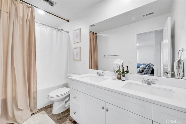 full bathroom with shower / tub combo with curtain, vanity, and toilet