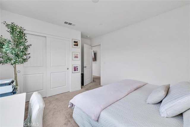 bedroom featuring light carpet, visible vents, and a closet