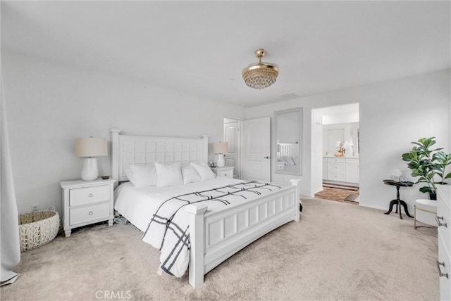 bedroom featuring light colored carpet and connected bathroom