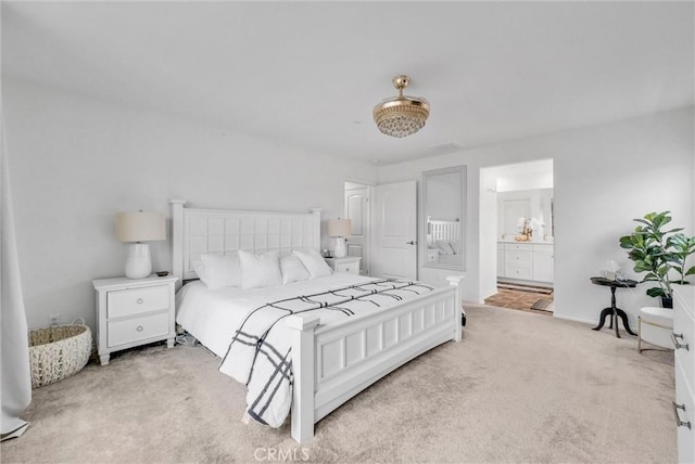 carpeted bedroom featuring baseboards and connected bathroom