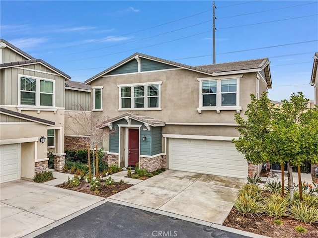 view of front of property featuring stucco siding, driveway, stone siding, and a garage